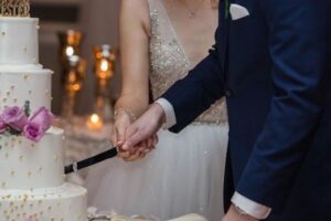 bride-and-groom-cutting-cake-hands