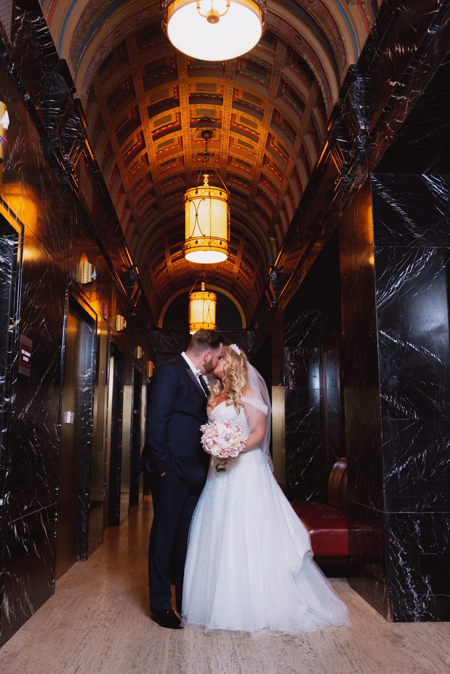 bride and groom kissing in broderick tower