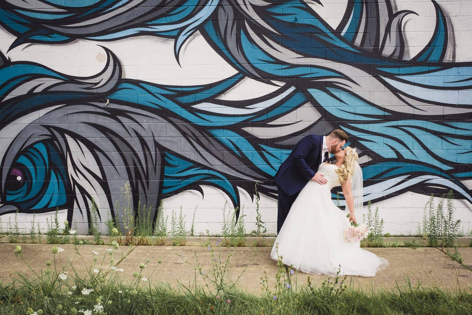 bride and groom kissing by detroit street art