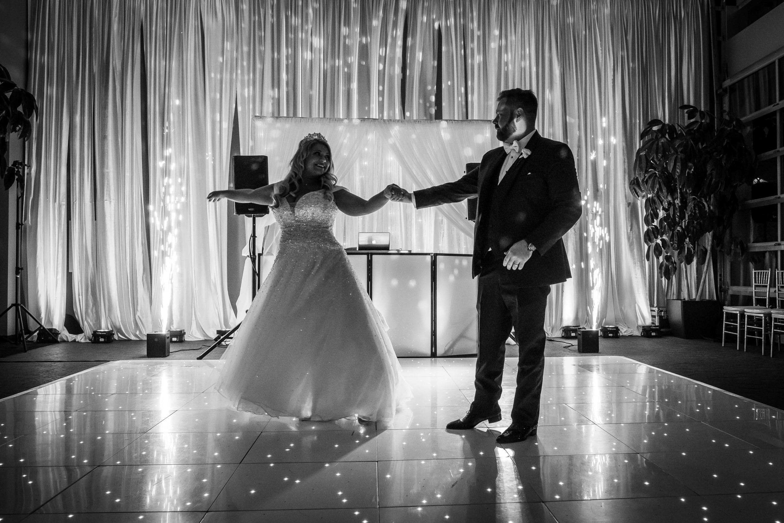 black and white photo of bride and groom dancing 