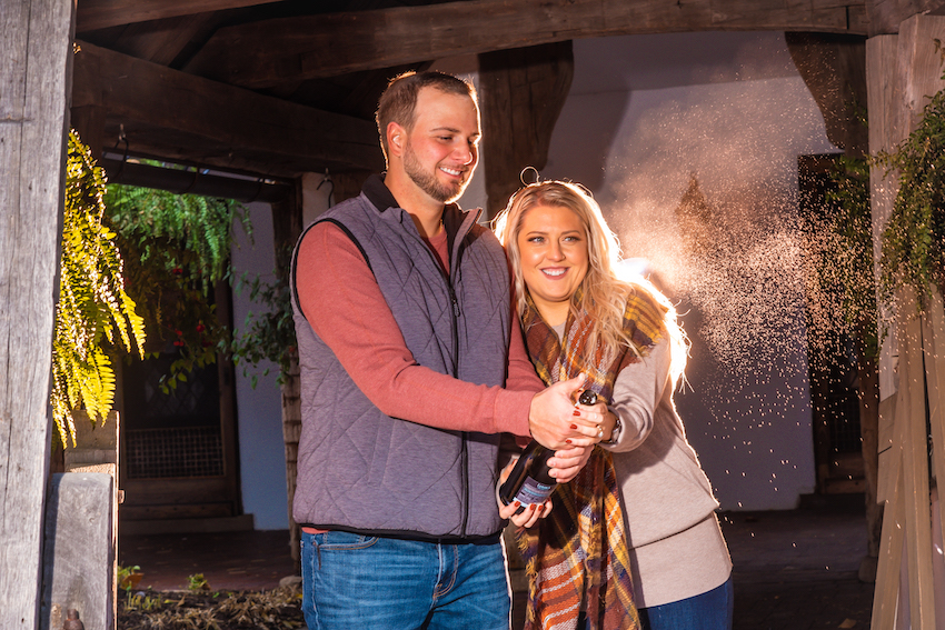 popping champagne at fall engagement session