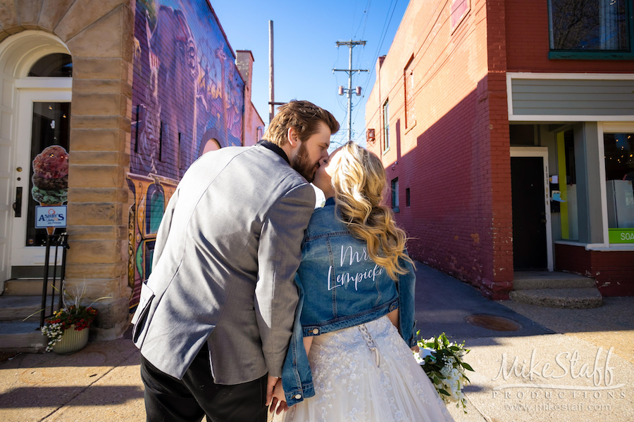 bride and groom jean jacket kissing