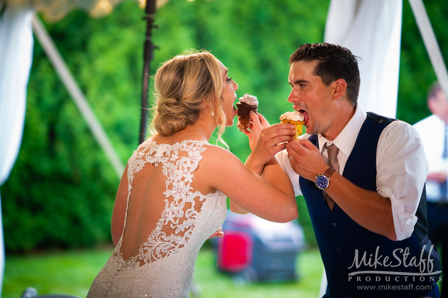 bride and groom eating cupcakes