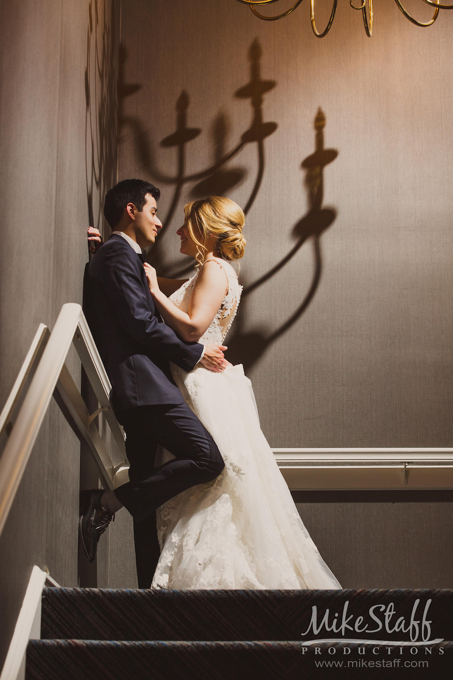 bride and groom leaning on wall