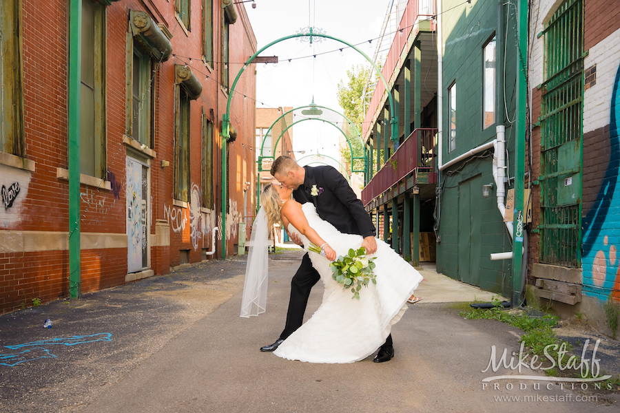 bride and groom kissing in alley in pontiac