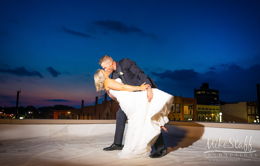 bride and groom kissing on rooftop