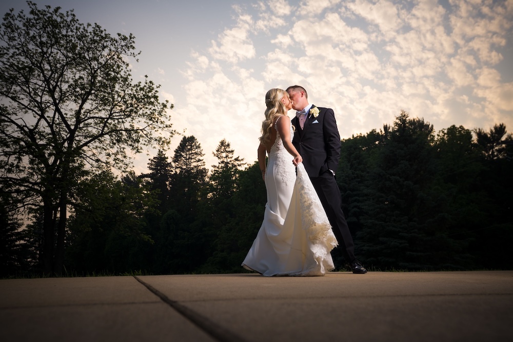 bride and groom kissing under sunset_Detroit Wedding Photography_Mike Staff Productions_Pine Knob_Mozark